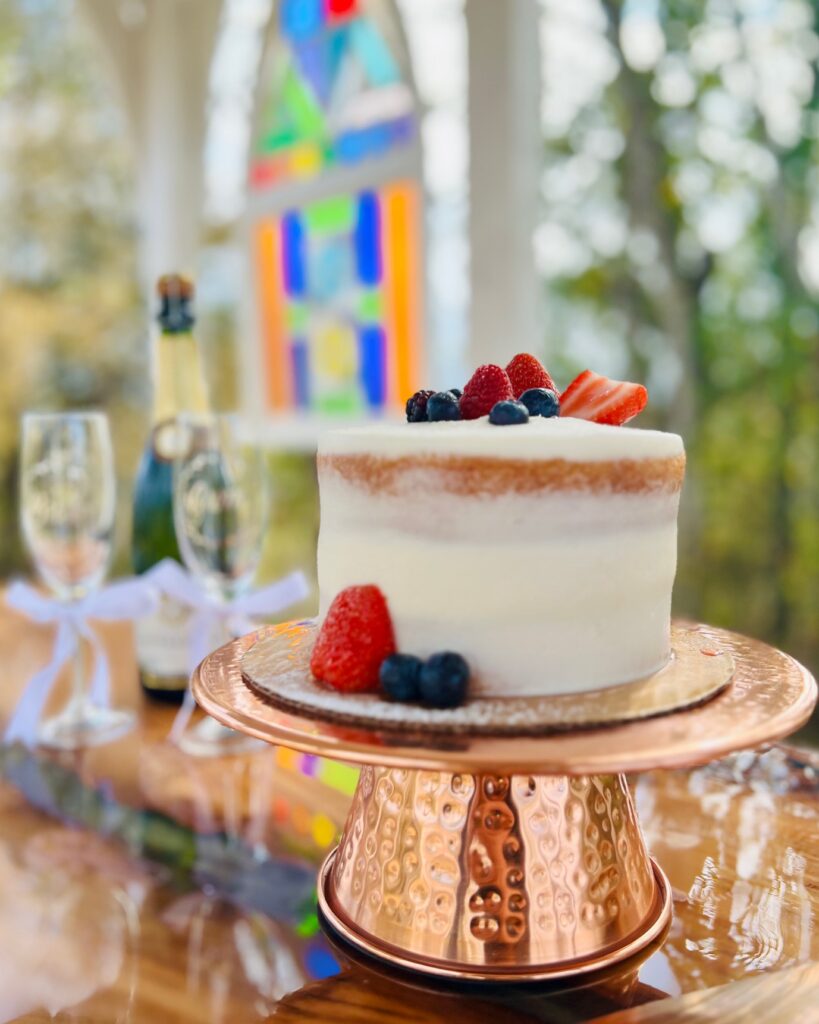 Wedding Cake with champagne and stained glass in background